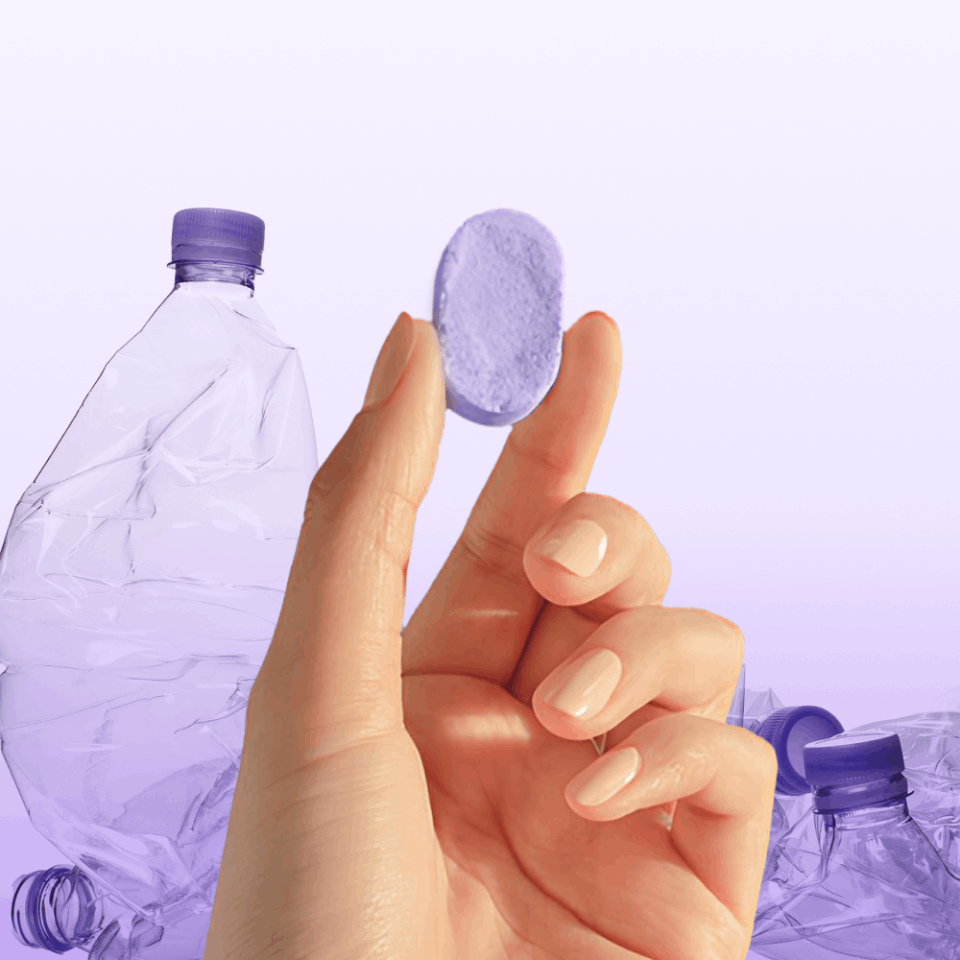 A concentrated cleaning tablet held between fingers